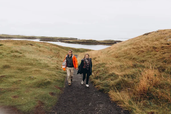 Front view of couple walking among the hills