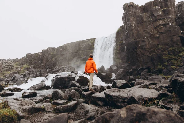 Młody Człowiek Chodzenie Pobliżu Wodospadu Ponury Dzień — Zdjęcie stockowe
