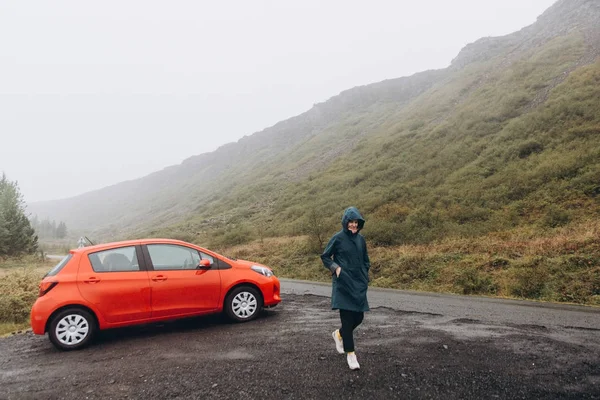 Jovem Mulher Saindo Carro Vermelho Dia Chuvoso — Fotografia de Stock