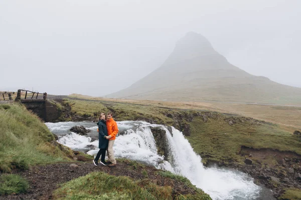 Junges Paar Hält Händchen Düsterem Tag Auf Wasserfall Hintergrund — Stockfoto