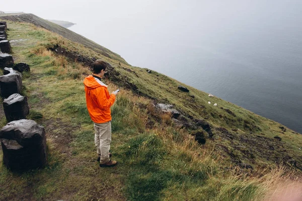 Tepede duran ve doğal manzarayı genç adam