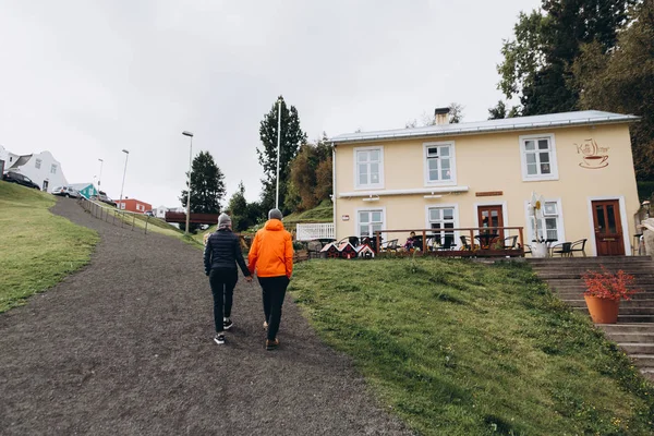 Young couple walking by gravel path and holding hands