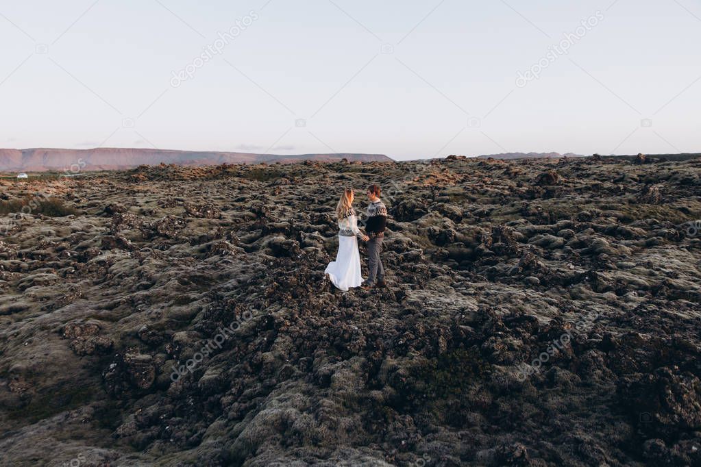 side view of couple holding hand in hand on mountains background