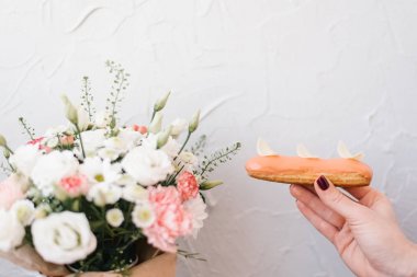 Camlı pasta rahat çiçek arka plan üzerinde tutmak el