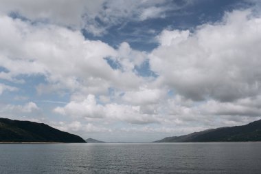 Sahil okyanus ve yağmurlu bulutlar gökyüzünde rocky Dağları'nın görünümü