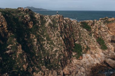 Adam cliff deniz arka plan üzerinde ayakta görünümünü gözlemleyerek