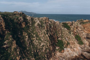 Adam cliff deniz arka plan üzerinde ayakta doğal görünümünü