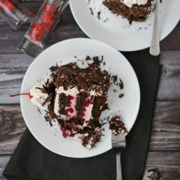 Nahaufnahme Von Schokoladenkuchen Mit Kirschen Und Joghurtfüllung Auf Weißen Tellern — Stockfoto