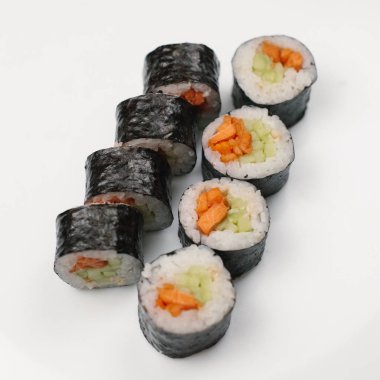 Japon rulo somon ve beyaz tabakta salatalık ile