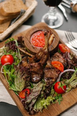 Kiraz domates, roka, marul ve ahşap tabak baharatlı sosu ile servis Kuzu Izgara raf Görünümü Kapat