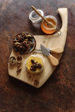 Natürmort bal kavanozu ve ceviz ile iştah açıcı Brie ahşap masaya servis.