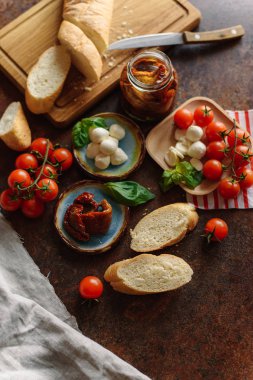 Kiraz domates, mozzarella ve kurutulmuş domates ile baget sandviçler için ahşap masa yılları arasında görev yapmıştır.