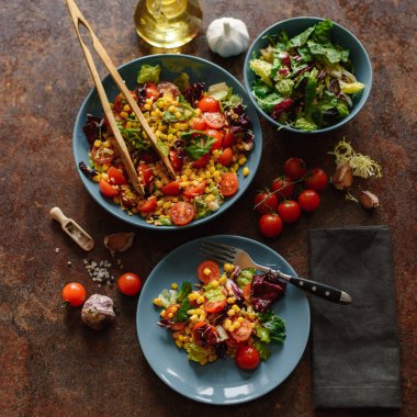 Mısır, domates, marul, lahana ve maydanoz mavi plakaları baharatlı sos ile vejetaryen salatası