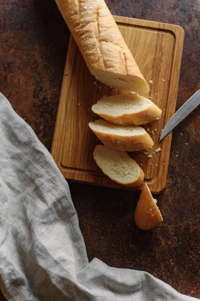 Baguete Fatiada Apetitosa Servida Tábua Corte Madeira Com Faca Guardanapo — Fotografia de Stock