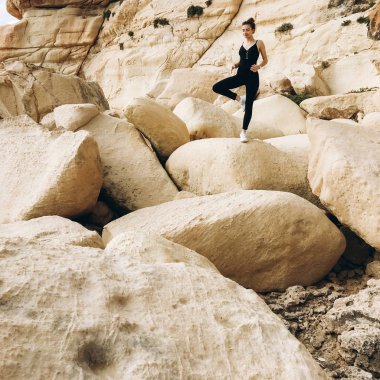 yoga poz, siyah giysili genç erkek görünümünü büyük rocky Dağları Sahil gün zaman, Tarih