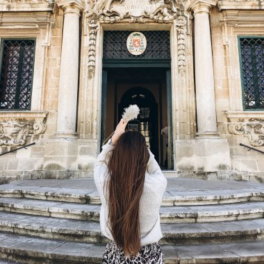arkadan görünümü olan genç kadın uzun saçlı ayakta merdivenlerde yakınındaki tarihi binanın büyük kapı