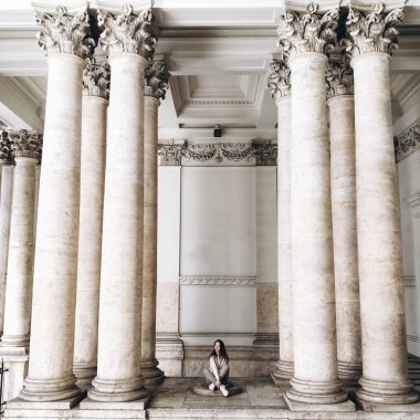 genç kadının yanına sütunlar ile eski bina görünümünü