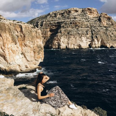 sahil, rocky Dağları üzerinde siyah giysili genç erkek ile yağmurlu bulutlar gökyüzünde görünümünü 