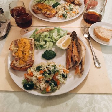 lezzetli yemek ızgara balık, limon ve beyaz tabakta sebze yakın çekim 