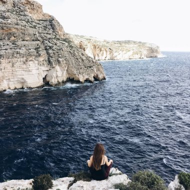 arkadan görünüşü rocky Dağları üstünde tepe-in rahatlatıcı sahil karanlık su ile siyah giysili genç erkek rüzgarlı gün