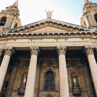Alt görünümü dekore edilmiş cephe eski bina heykeller, ayağı ile sarı ve mavi gökyüzü karşı sıva.