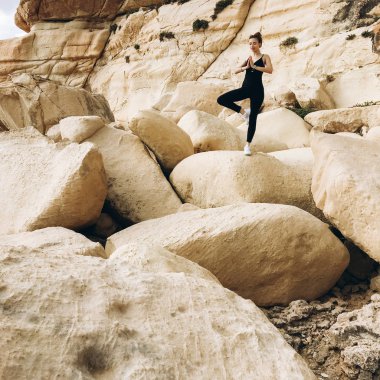 yoga poz, siyah giysili genç erkek görünümünü büyük rocky Dağları Sahil gün zaman, Tarih