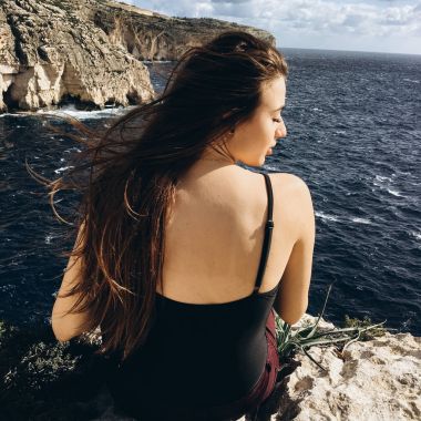 arkadan görünüşü rocky Dağları üstünde tepe-in rahatlatıcı sahil karanlık su ile siyah giysili genç erkek rüzgarlı gün