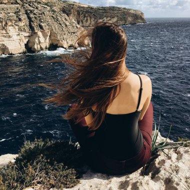 arkadan görünüşü rocky Dağları üstünde tepe-in rahatlatıcı sahil karanlık su ile siyah giysili genç erkek rüzgarlı gün