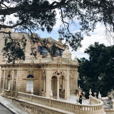 Siyah romper, sarı jumper ve vintage house balkonda yürüyüş beyaz spor ayakkabı giyen kadın görünümünü.