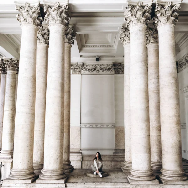 genç kadının yanına sütunlar ile eski bina görünümünü