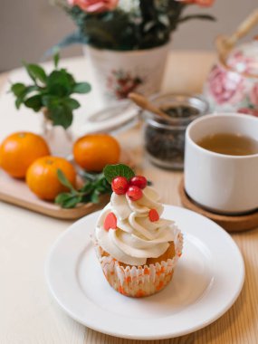 Beyaz çay seti ve mandalina masada tabakta vanilyalı kek