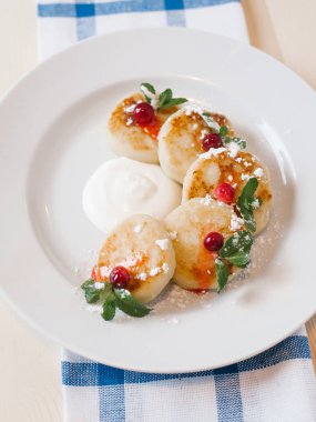 Krem peynir krep nane ile beyaz tabakta üstten görünüm bırakır, ekşi krema ve kızılcık