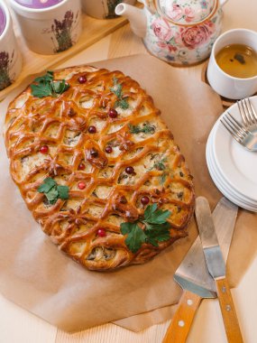 Dekoratif net, çilek ile pasta pişmiş, frenk üzümü yaprakları çatal, spatula, çay ve Kupası ile plakalar ile servis