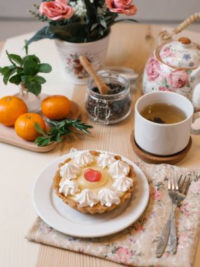 Krem şanti ile meyve tart çay seti, mandalina ve çiçekler ile servis