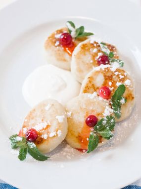 Nane yaprakları, ekşi krema ve cranberries ile beyaz tabakta servis krem peynirli gözleme