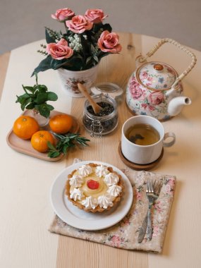 Krem şanti ile meyve tart çay seti, mandalina ve çiçekler ile servis