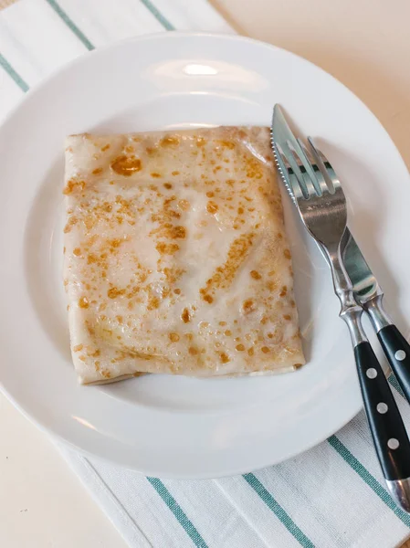 用餐具和条纹餐巾在白色盘子上的填充薄饼 — 图库照片