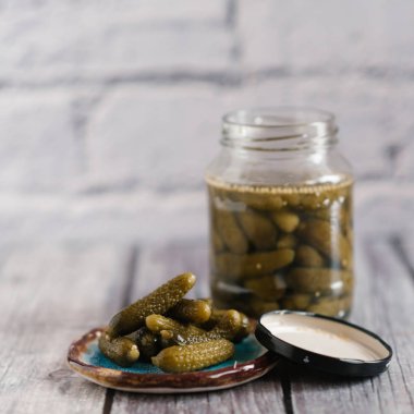 Close-Up plaka üzerinde ve cam ahşap masa üzerinde salatalık turşusu