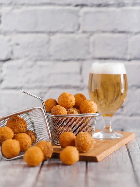 close-up of delicious cheese balls in metal box with craft beer on grey brick wall background