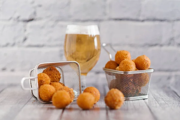 close-up of homemade delicious cheese balls with craft beer on grey brick wall background