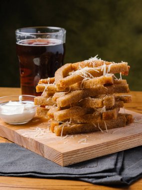 Ahşap kesme tahtası koyu bira cam ile ekmek tost parmesan ve sarımsak sosu ile servis 