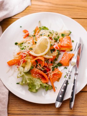 Dilimlenmiş salatalık, somon, marul, rendelenmiş parmesan ve Susam salata