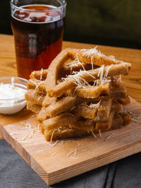 Ahşap kesme tahtası koyu bira cam ile ekmek tost parmesan ve sarımsak sosu ile servis 