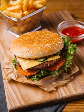Kızartma sepeti ve tatlı ketçap ile iştah açıcı çizburger Görünümü Kapat üzerinde Ahşap doğrama tahtası hizmet