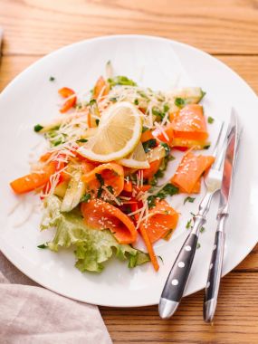 Dilimlenmiş salatalık, somon, marul, rendelenmiş parmesan ve Susam salata