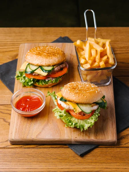 Zamknij Widok Cheeseburgery Frytkami Kosz Słodki Ketchup Drewniana Deska Krojenia — Zdjęcie stockowe