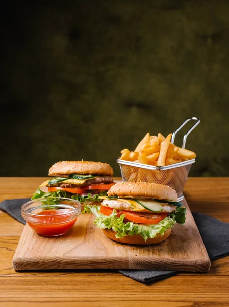 Çizburger ile lezzetli yemek sepeti ve Ahşap doğrama tahtası ve gri peçete tatlı ketçap patates kızartması ile servis