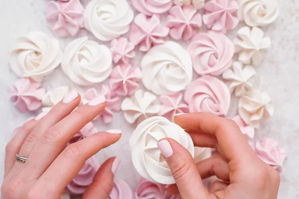 Mano Femminile Che Tiene Meringa Bianca Sfondo Bianco Rosa Pastello — Foto Stock