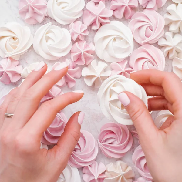 Mano Femminile Che Tiene Meringa Bianca Sfondo Bianco Rosa Pastello — Foto Stock