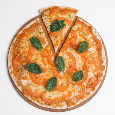 Pizza ahşap pizza tabakta domates sos, mozzarella, parmesan, domates ve ıspanak yaprakları ile